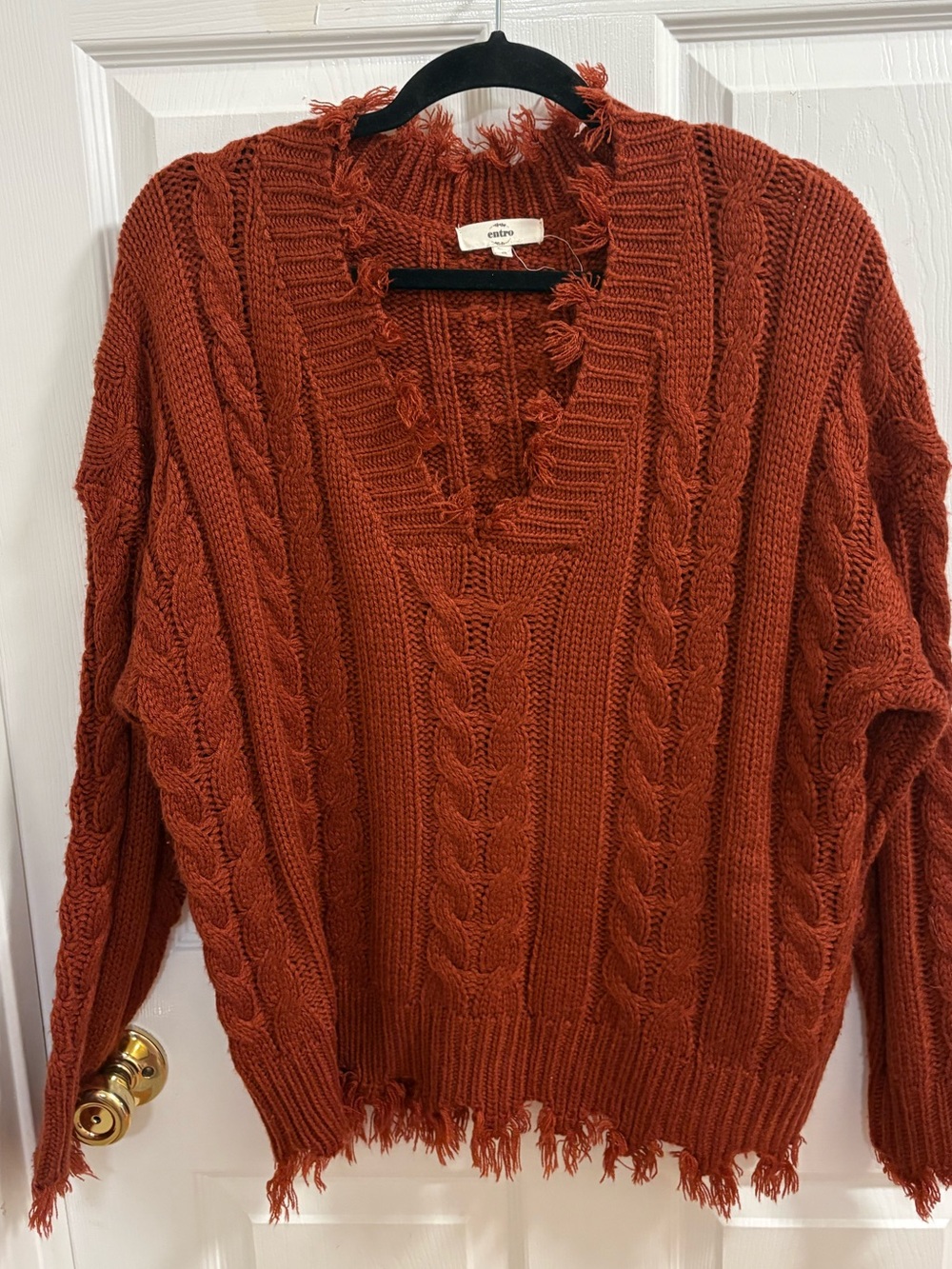 Entro chunky cable knit pattern with a deep V-neckline, distinctive frayed fring